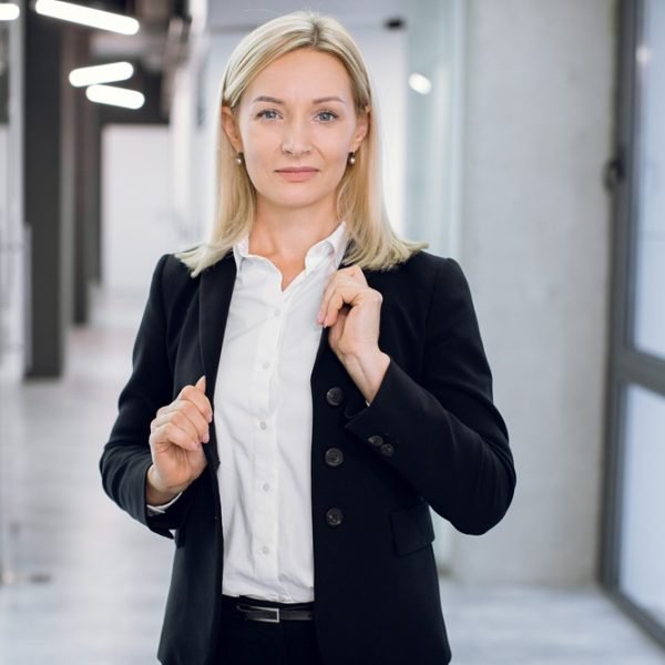 People, business, office, company worker concept. Close up portrait of charming smiling 40 years old lady with blond hair, in formal clothes, posing to camera in front of modern loft light office.